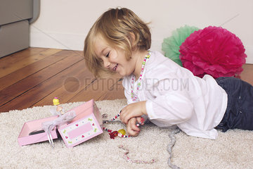 Little girl removing necklace from jewellery box