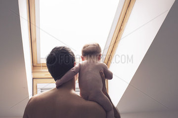 Father carrying baby on shoulder  rear view