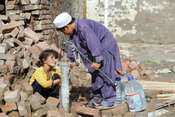 Nowshera  Pakistan  Kinder pumpen Wasser aus einer alten Handpumpe
