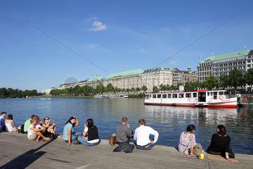 Hamburg  Deutschland  Menschen sitzen auf einem Steg an der Binnenalster