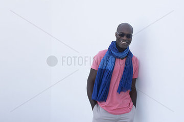 Man wearing scarf and sunglasses  smiling  portrait
