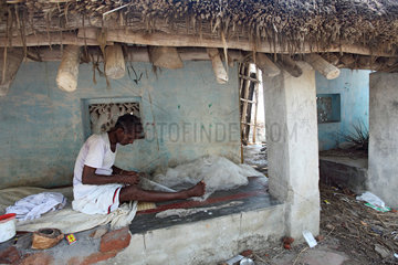 Kokilamedu  Indien  ein Fischer bessert seine Netze in seinem zerstoerten Haus aus