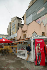 Przemysl  Polen  Frau steht an einem Kiosk neben Coca-Cola-Reklame