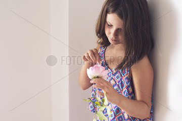 Girl picking petals from rose