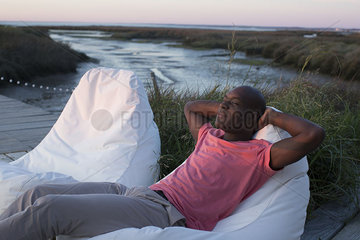 Man relaxing at water's edge