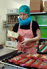 Berlin  Deutschland  Mitarbeiterin verpackt fertiggestellte Schokoladentafeln