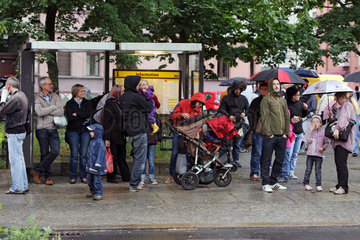 Berlin  Deutschland  Menschen warten bei Regen an einer Bushaltestelle auf den Bus