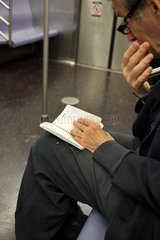 New York  USA  aelterer Mann in der Subway in Manhattan schaut in sein Notizbuch