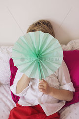Little boy hiding behind tissue paper flower