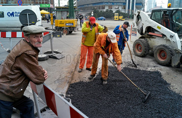 Kattowitz  Polen  Bauarbeiter reparieren eine Strasse mit Asphalt
