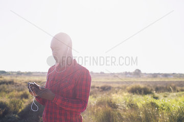 Man listening to music with earphones outdoors