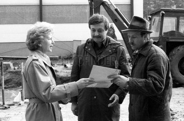 Berlin  DDR  Frau ueberreicht einem Mann einen Bauauftrag