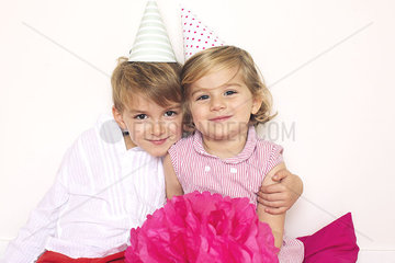 Brother and sister wearing party hats  portrait