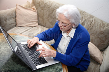 Berlin  Deutschland  eine alte Frau schreibt am Laptop