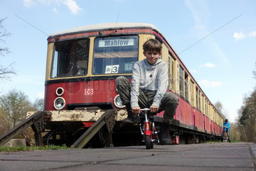 Zossen  Deutschland  Junge faehrt auf einem Minifahrrad vor einem S-Bahnwaggon