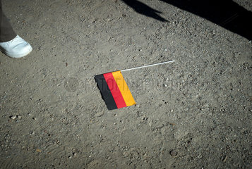 Berlin  Deutschland  Deutschlandfaehnchen liegt auf dem Boden