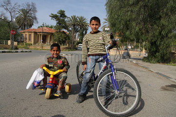 Nikosia  Tuerkische Republik Nordzypern  ein Junge in Militaerkleidung auf einem Dreirad mit seinem Freund