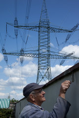 Werben  Deutschland  ein Mann in seinem Garten mit Strommasten im Hintergrund