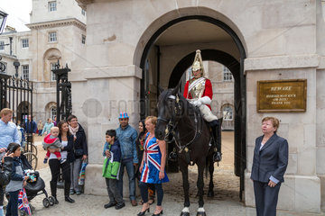 London  Grossbritannien  Soldat der Horse Guards posiert mit Touristen fuer Urlaubsfotos