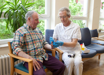 Essen  Deutschland  ein Altenpfleger misst einem Patienten den Blutzucker