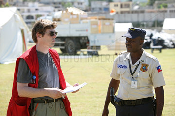 Carrefour  Haiti  DRK Mitarbeiter im Gespraech mit dem Mitarbeiter einer Sicherheitsfirma