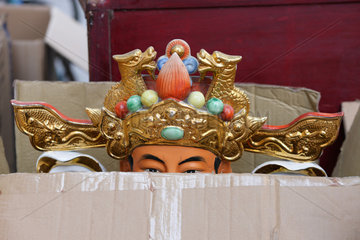 Shenzhen  China  in einem aufgerissenen Karton steht eine Figur in Kostuemen der Chinesischen Ope
