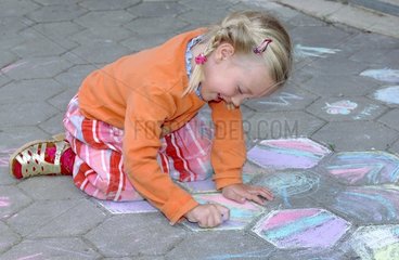 Maedchen malt mit Kreide