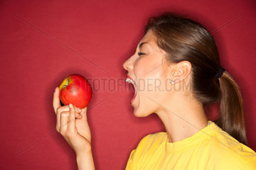 Freiburg  Deutschland  junge Frau isst einen Apfel
