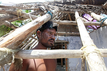 Kokilamedu  Indien  ein Mann steht in seinem zerstoerten Haus