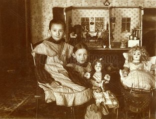Maedchen spielen mit Puppen  1905