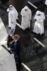 Dubai  Vereinigte Arabische Emirate  Vogelperspektive  Maenner in Landestracht und elegant gekleidetes Paar