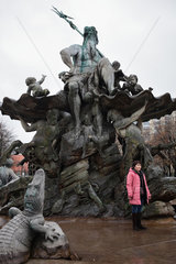 Berlin  Deutschland  eine Touristin steht im Neptunbrunnen am Alexanderplatz