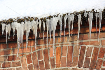 Wustrow  Deutschland  Eiszapfen haengen am Dach eines Hauses