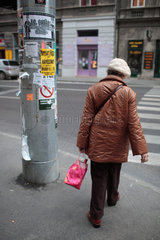 Budapest  Ungarn  Frau mit Einkaufstuete ueberquert die Strasse