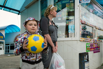 Lemberg  Ukraine  Junge mit einem Fussball in ukrainischen Farben an einer Bushaltestelle