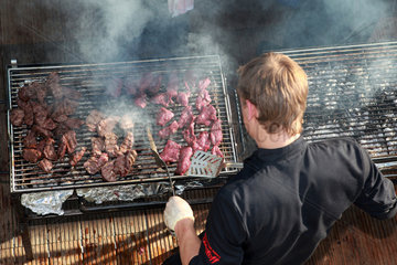 Hannover  Deutschland  Mann bereitet Fleisch auf einem Grill zu