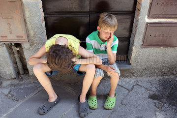 Bolsena  Italien  Jungen sitzen erschoepft auf einer Treppenstufe