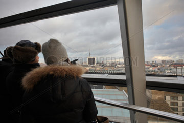 Berlin  Deutschland  Besucher in der Reichstagskuppel stehen am Fenster und blicken ueber Berlin