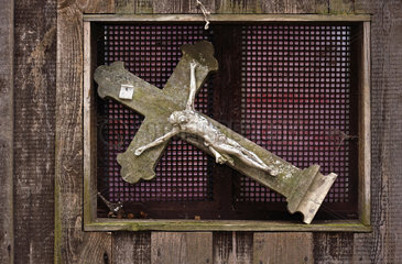 uraltes Kreuz in einer Fensternische  Symbol Krise der Kirche