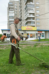 Lemberg  Ukraine  staedtische Angestellte maehen den Rasen vor einer Hochhaussiedlung