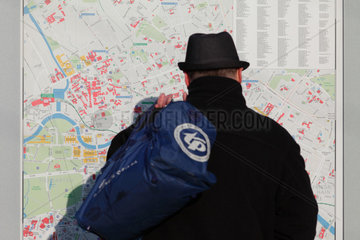 Berlin  Deutschland  Mann betrachtet einen Stadtplan auf dem Alexanderplatz