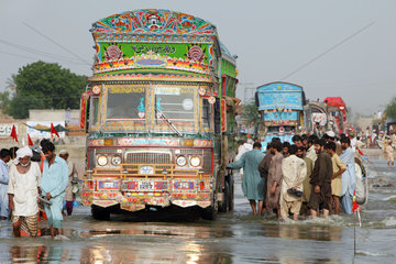 Muzaffargarh  Pakistan  Menschen durchwaten ueberflutete Strassen