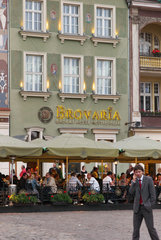 Posen  Polen  junger Mann telefoniert mit Handy vor dem bekannten Hotel Brovaria
