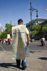 Berlin  Deutschland  ein Mann verteilt kostenlose Stadtplaene fuer Berlin am Kudamm
