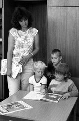 Berlin  DDR  Vorschulkinder schauen sich in einer Bibliothek ein Buch an