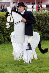 Hamburg  Deutschland  Frau imitiert Dressurreiten auf einem Pferd aus Pappe