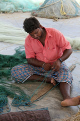 Kokilamedu  Indien  ein Fischer beim Ausbessern seiner Netze
