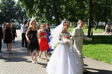 Gomel  Weissrussland  Hochzeitspaar mit Hochzeitsgesellschaft beim Spaziergang