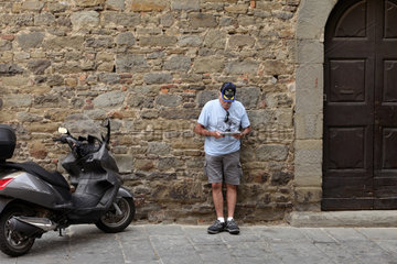Cortona  Italien  ein Mann liest in einem Tablet-PC