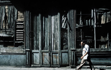 Havanna  Kuba  Mann laeuft an einem ehemaligen verfallenen Restaurant vorbei